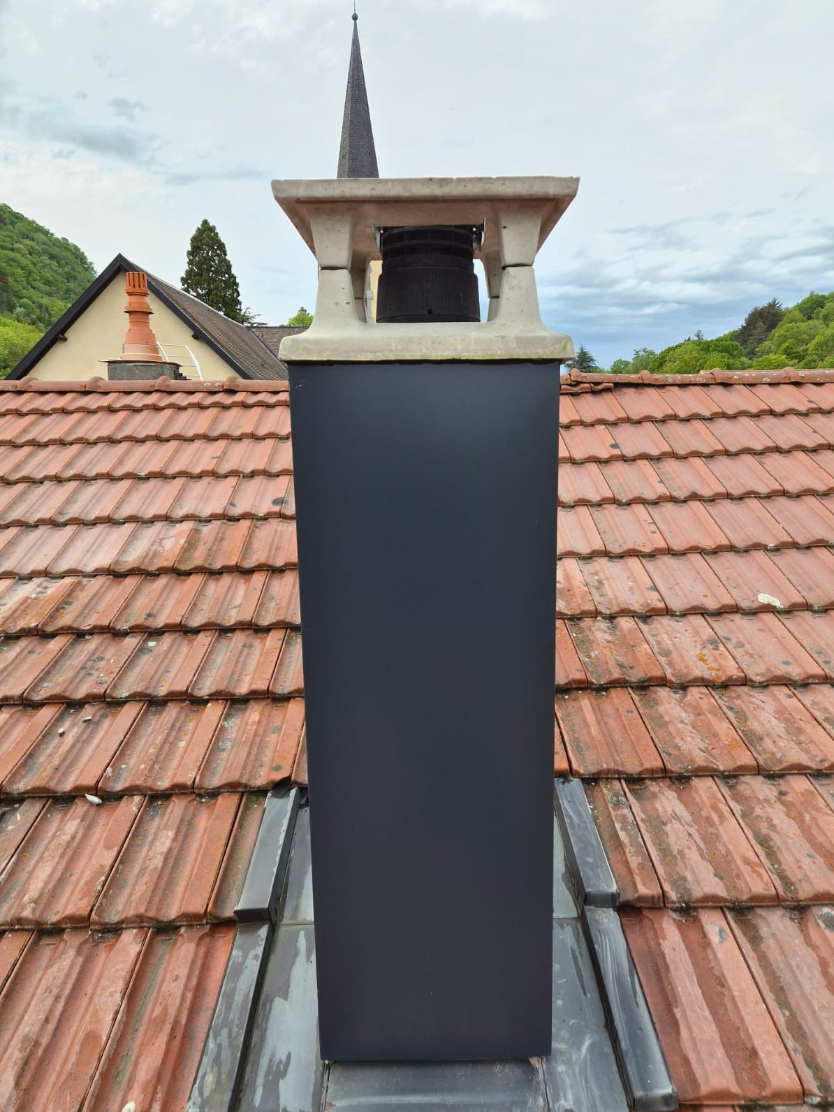 Après : souche de cheminée habillée de tôle anthracite, raccord en zinc