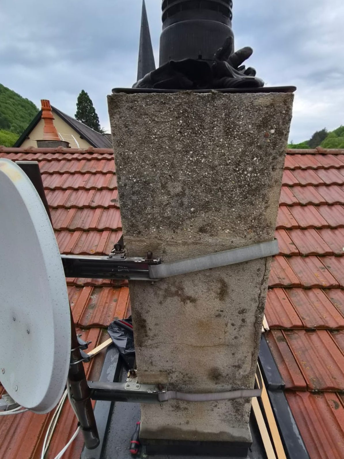 Avant : souche de cheminée en béton brut, fissurée, avec antenne