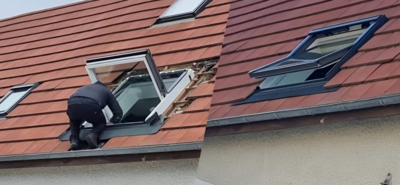 Pose d'une fenêtre de toit, couvreur dans l'ouverture du toit.
