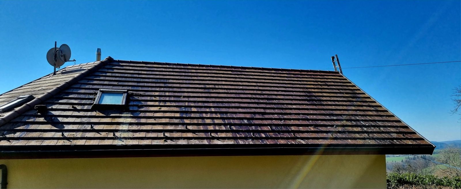 Toiture en tuiles avec une fenêtre de toit, vue de l'extérieur.